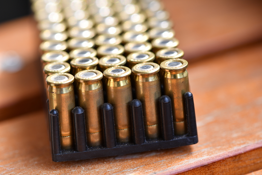 Shiny,Pistol,Ammunition,On,A,Wooden,,Brown,Table.
