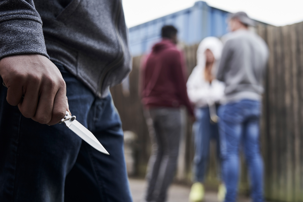 Close,Up,Of,Teenage,Boy,In,Urban,Gang,Holding,Knife