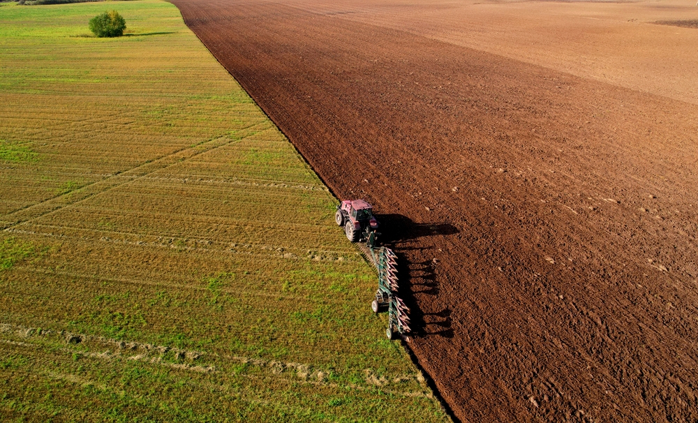 Tractor,Plowing,Field.,Red,Tractor,With,Plough,On,Plowed,,Aerial