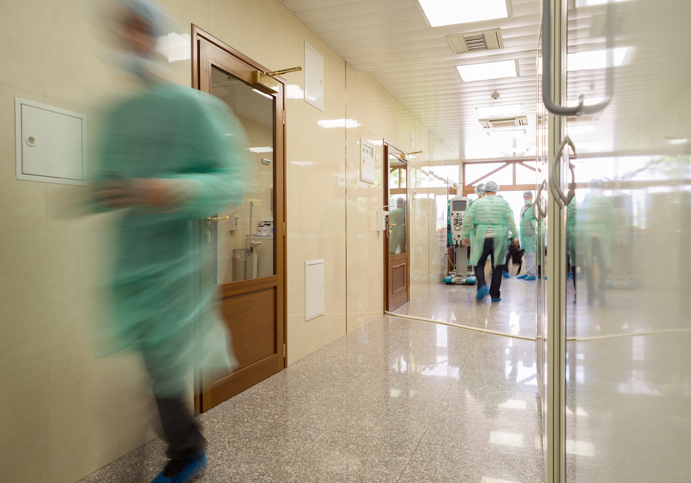 Blurred,Doctor,Figures,Wearing,Medical,Uniforms,Are,Seen,In,The