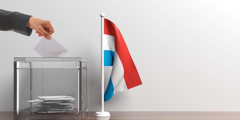 Electionsa,In,Luxembourg.,Voter,And,A,Glass,Ballot,Box,Next