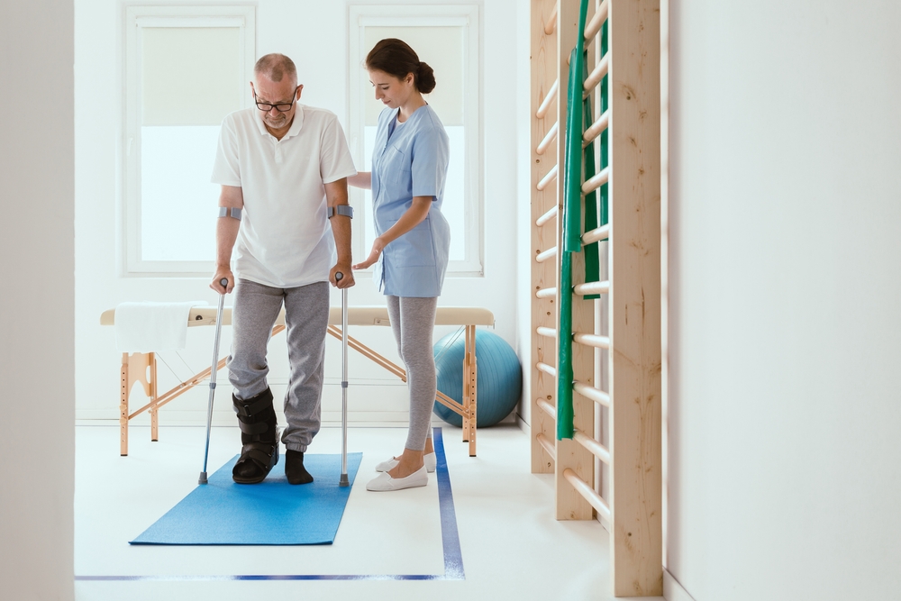Injured,Patient,In,A,Leg,Brace,Exercising,On,A,Blue