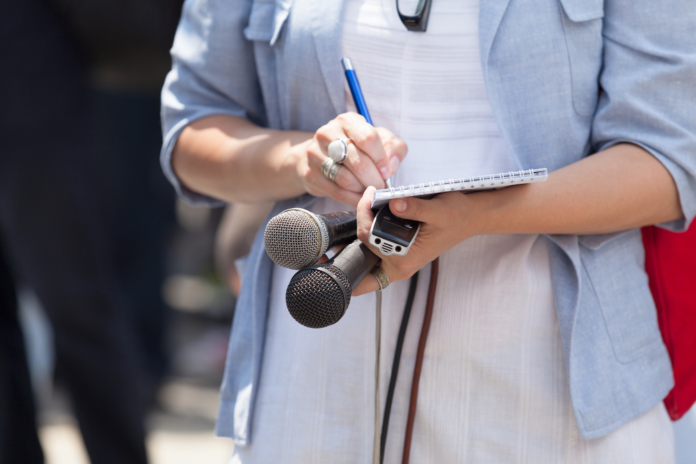 Female,Journalist,Taking,Notes,At,Press,Conference