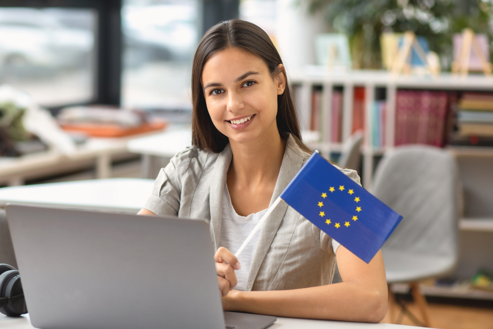 Beautiful,Woman,Student,With,Eu,Flag,Sitting,At,Table,With