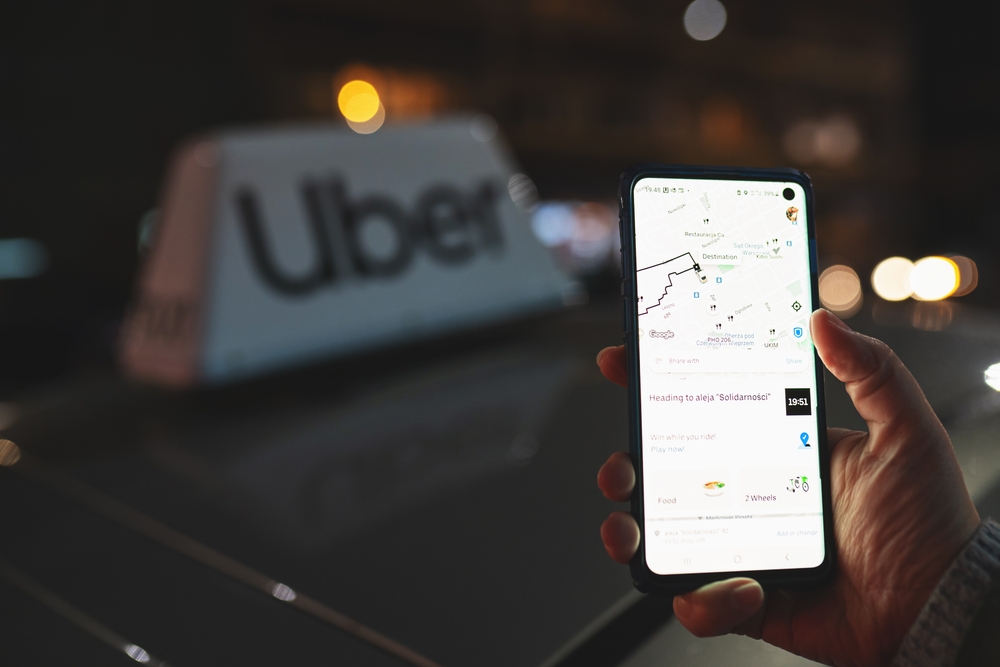 Uber,App,Displayed,On,Smartphone,Held,In,Hand,In,Front