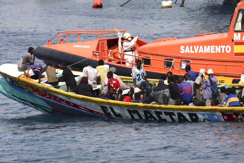 A sea rescue ship tows a small boat with 105 Sub Saharan illegal immigrants on board