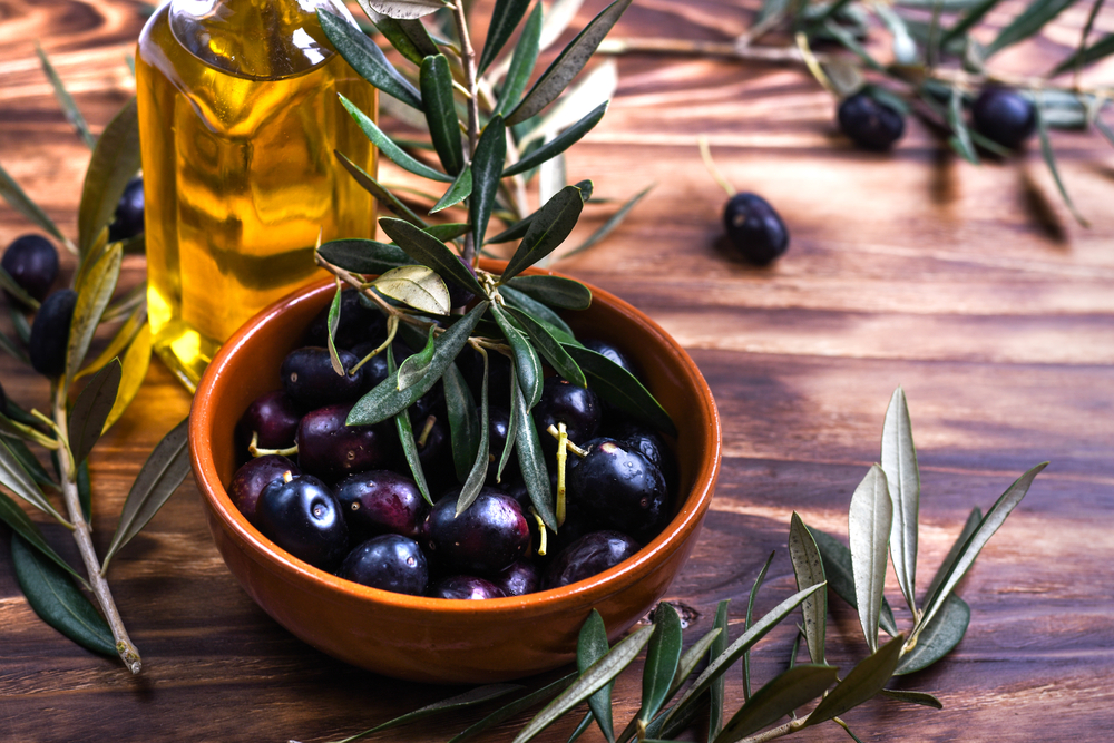 Black,Olives,Into,Ceramic,Pot,On,An,Old,Wooden,Table.