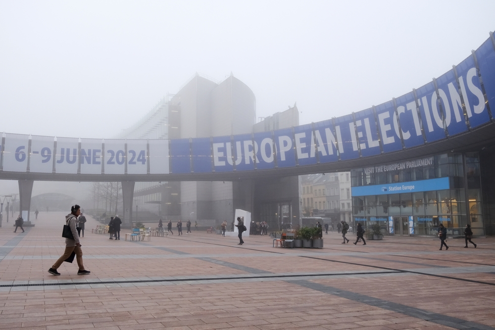 People,Walk,Toward,A,Banner,Advertising,The,European,Elections,Outside