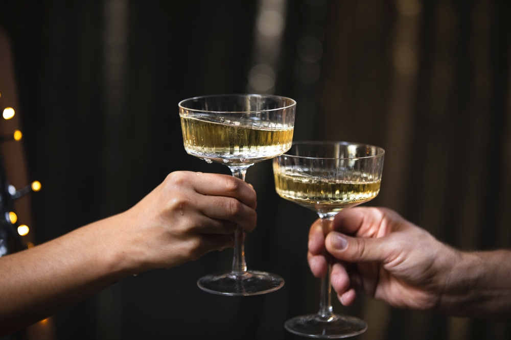 A,Girl,Holds,Glasses,Of,Champagne,In,Her,Hands,,Cheers