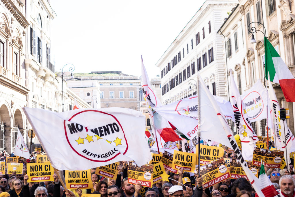 Supporters hold placards and flags as they take part during
