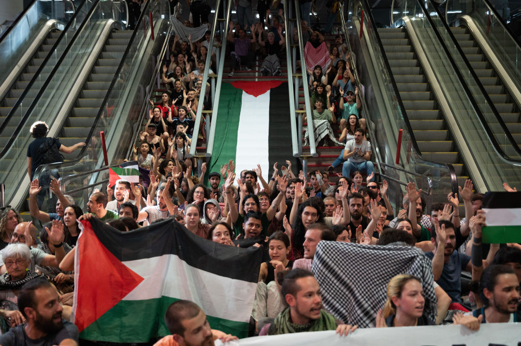 Protesters raising hands shouting slogans against Israel.