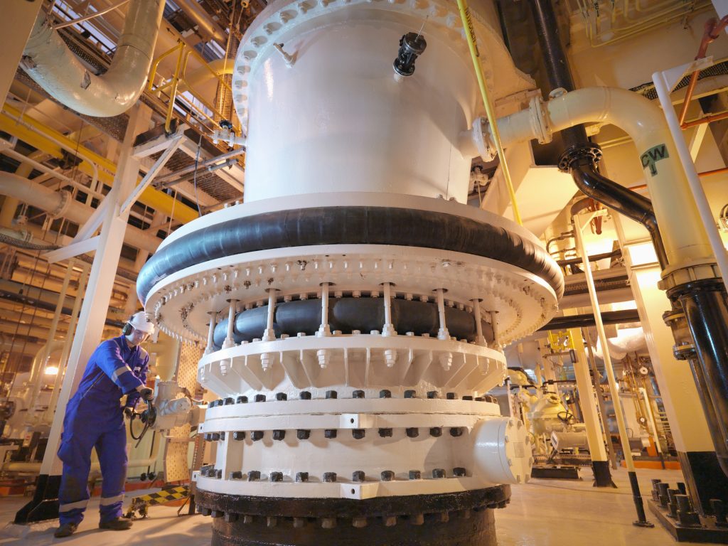 Engineer adjusting seawater valve in power