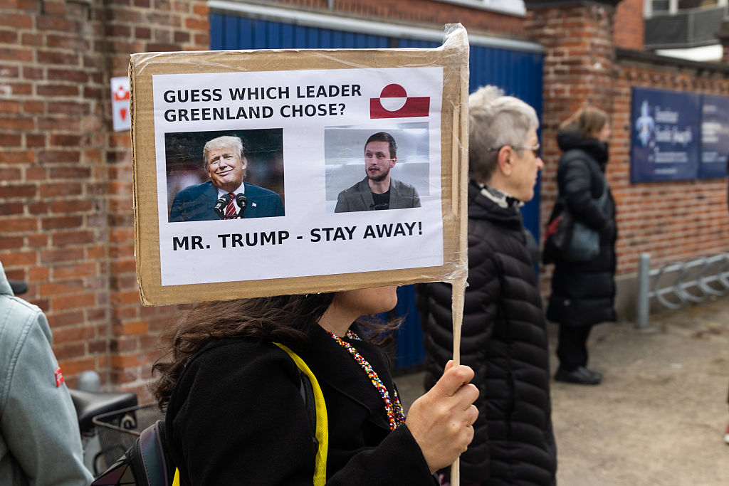 A protester holds a placard with a photo of United States